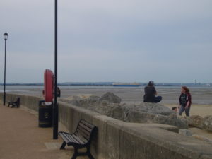 Looking out from Ryde Harbour wall across sands to shipping in Solent